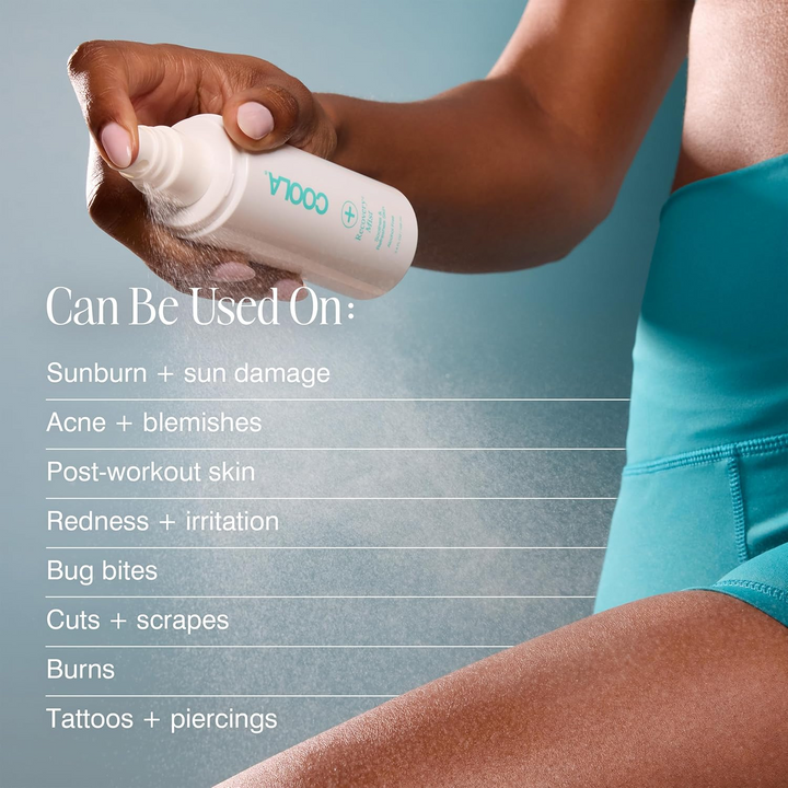 Person holding a bottle of COOLA Recovery+ Mist with product usage information on a gray background