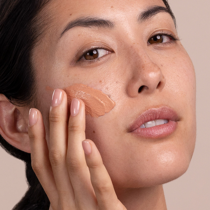 woman applying Eminence Organics Acne Advanced Clarifying Masque on her face