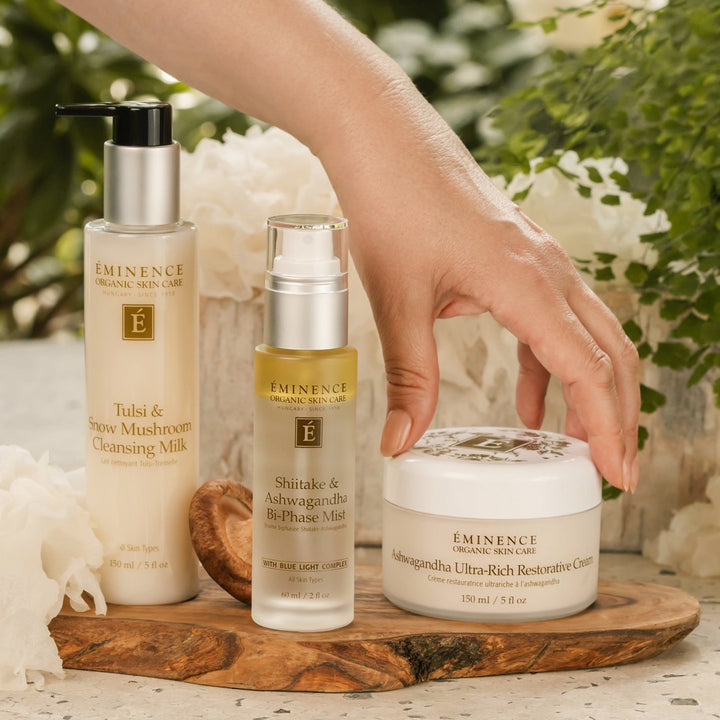 Eminence Organics Pure Forest Collection with model hand picking up the Eminence Organics Ashwagandha Ultra-Rich Restorative Cream