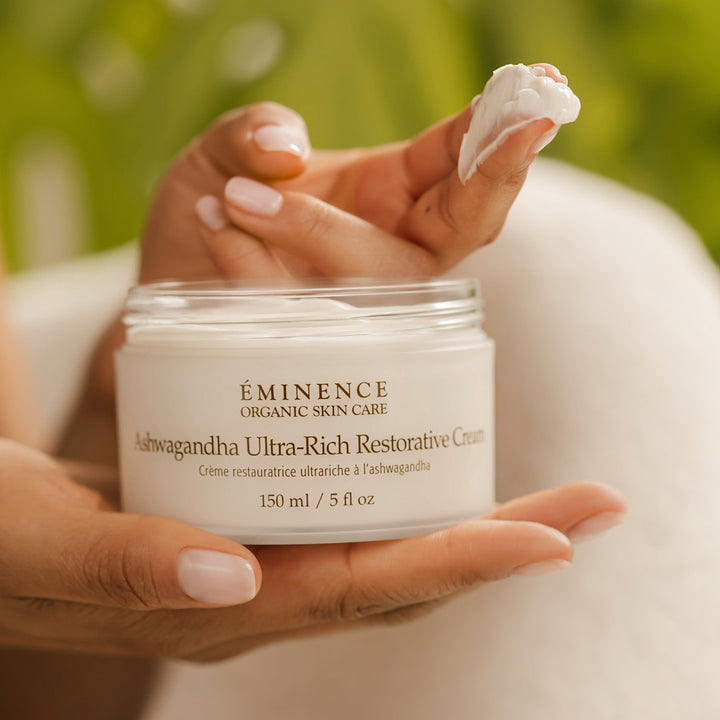 Eminence Organics Ashwagandha Ultra-Rich Restorative Cream with model hands and texture of product