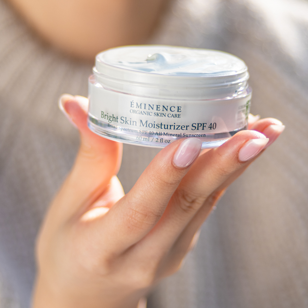 woman holding Eminence Organics Bright Skin Moisturizer SPF 40 in her hand