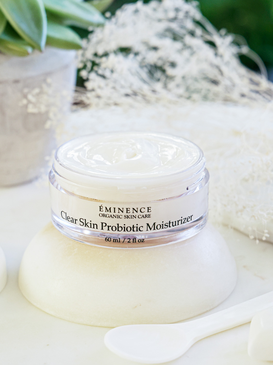 Eminence Clear Skin Probiotic Moisturizer jar on a white surface with a blurred natural background
