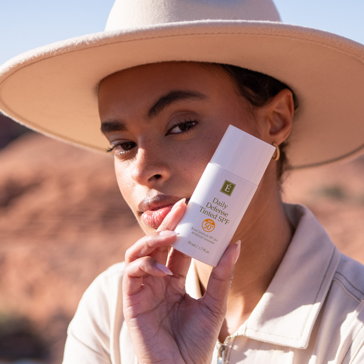 woman holding Eminence Organics Daily Defense Tinted SPF