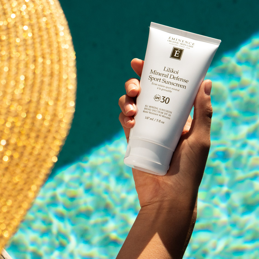 woman holiding Eminence Organics Lilikoi Mineral Defense Sport Sunscreen SPF 30 in her hand