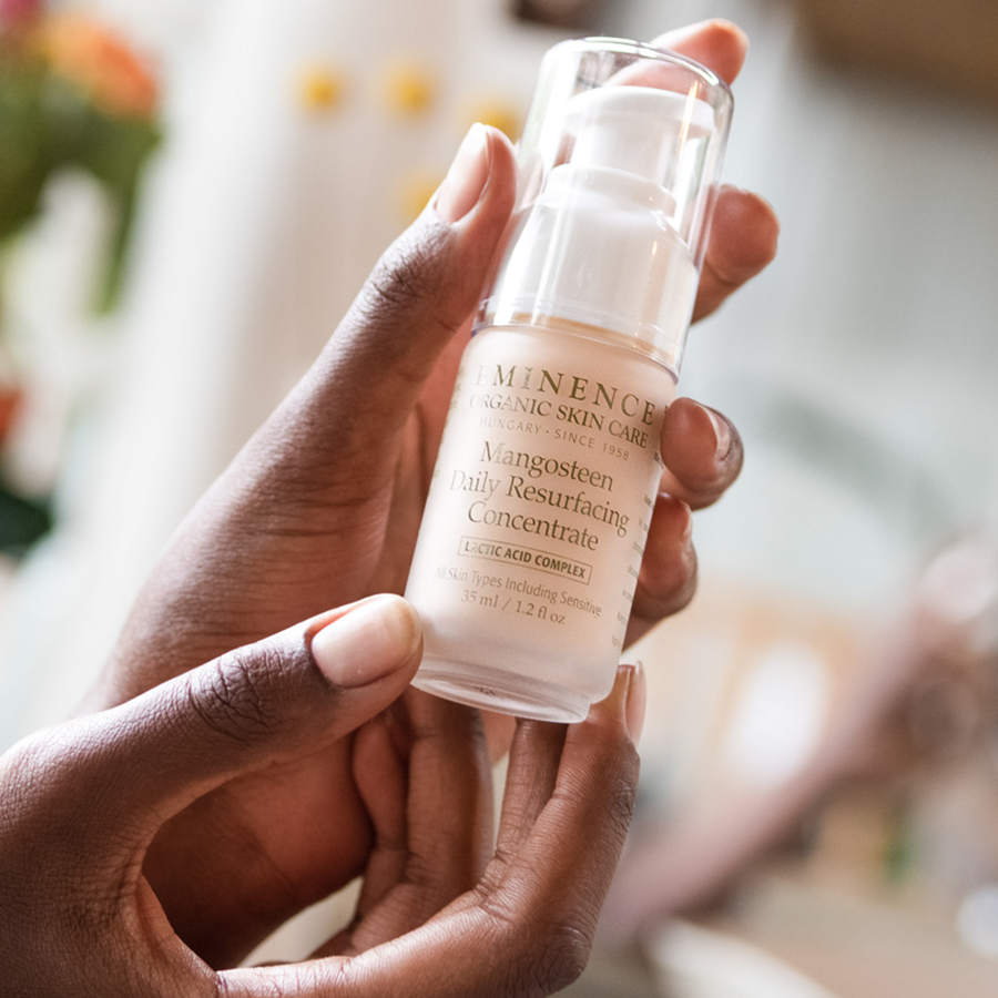woman holding Eminence Organics Mangosteen Daily Resurfacing Concentrate in her hand