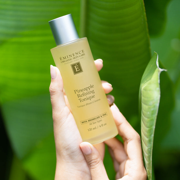 Woman holding Eminence Organics Pineapple Refining Tonique in her hand