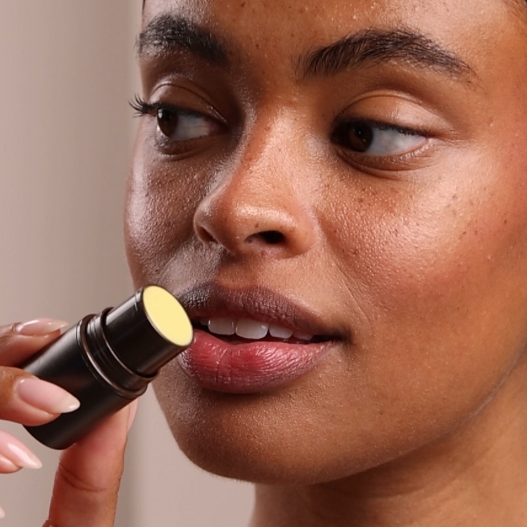 woman applying Eminence Organics Rosehip &amp; Lemongrass Lip Balm SPF 15
