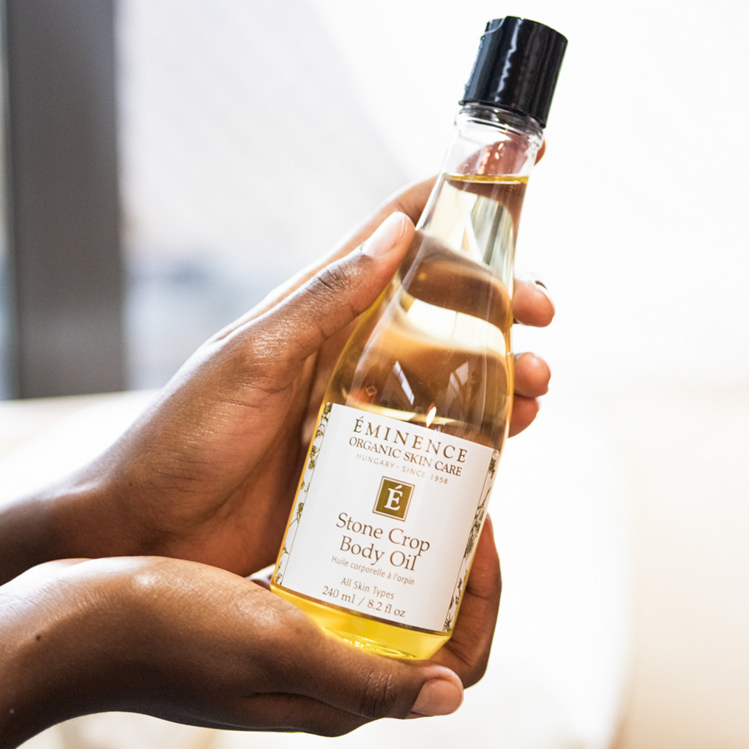 woman holding Eminence Organics Stone Crop Body Oil in her hands