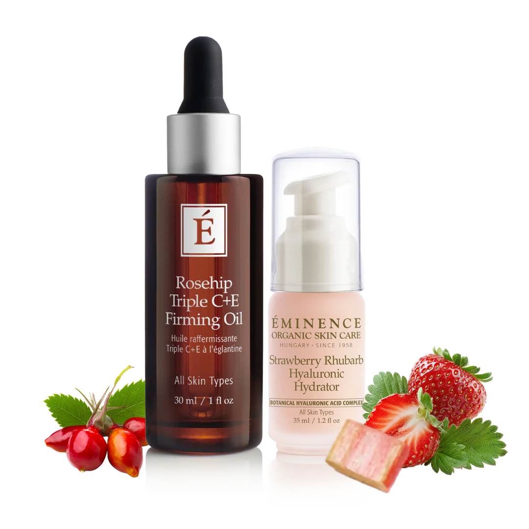 Two skincare bottles on a white background with strawberries and leaves as props. The left bottle is a dark amber dropper bottle labeled &