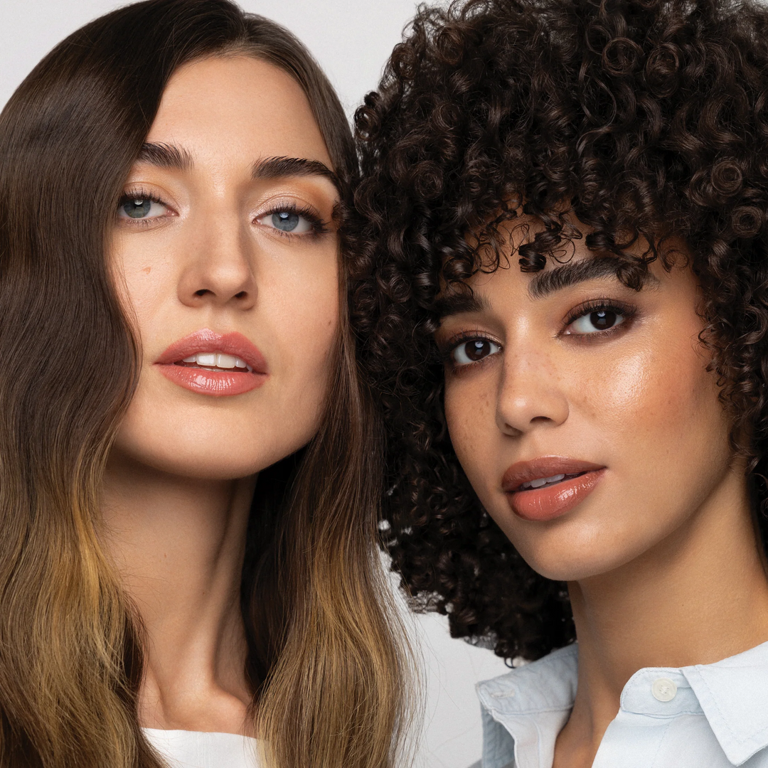 Two models side by side, one with long brown-to-blonde waves and the other with short, dark curls