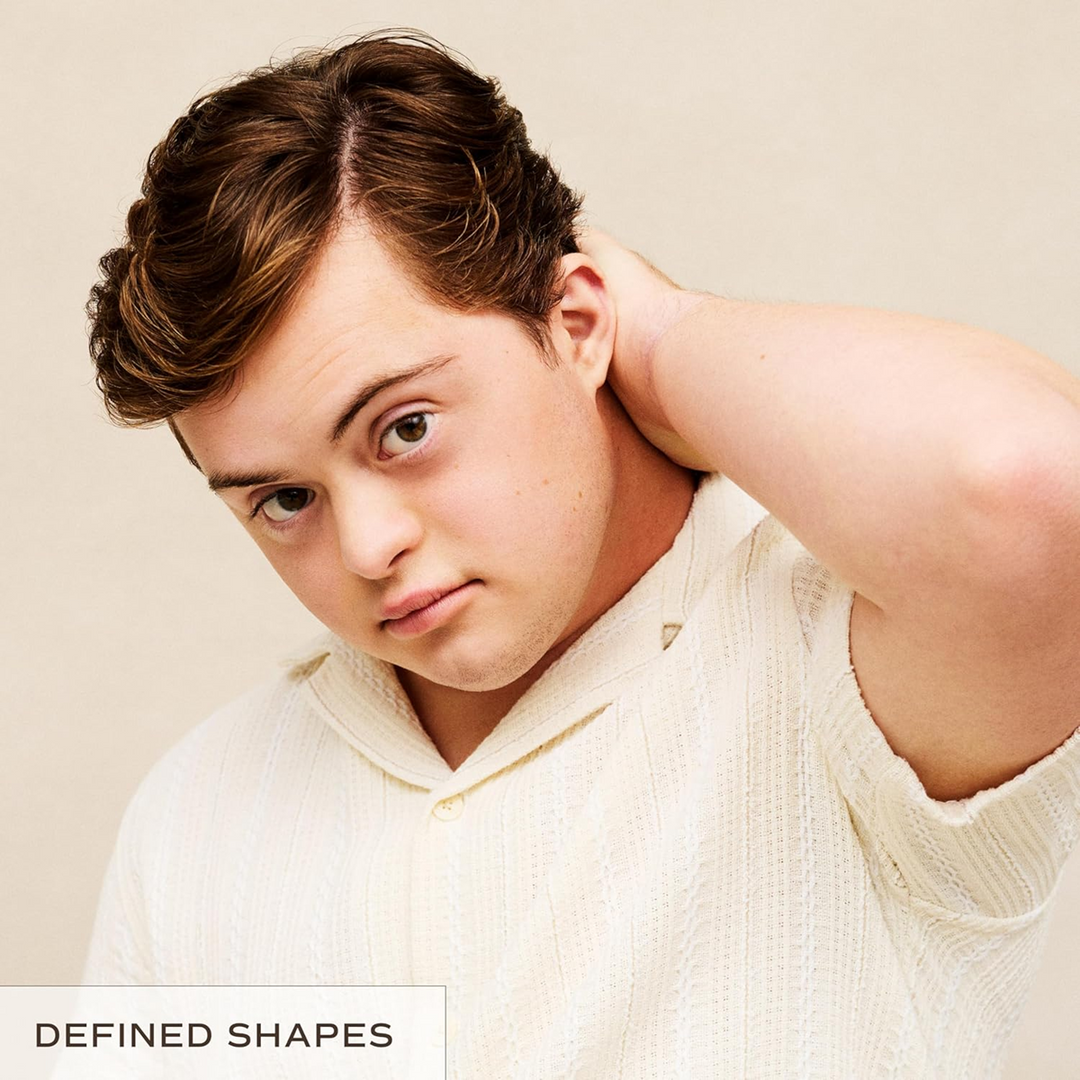 Man wearing a white sweater against a beige background with &