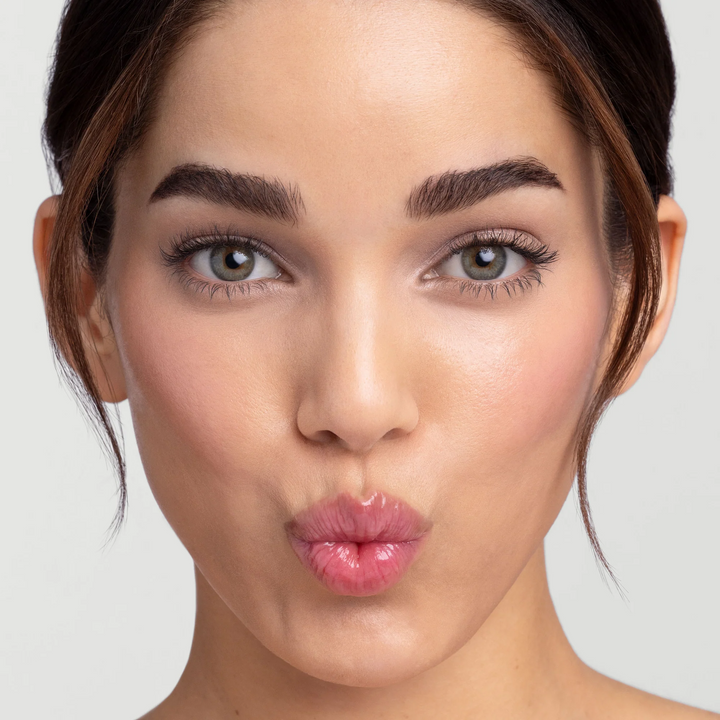 Woman wearing Jane Iredale Just Kissed pH Lip Oil blooming pink on her lips