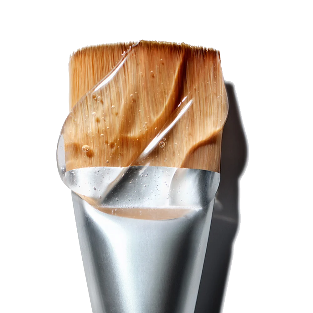NuFACE Clean Sweep Applicator Brush with cosmetic product on a white background