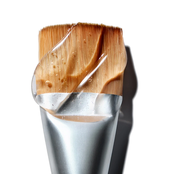 NuFACE Clean Sweep Applicator Brush with cosmetic product on a white background