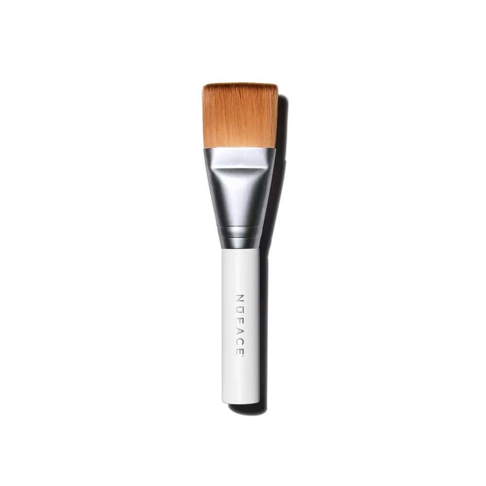 A NuFACE Clean Sweep Applicator Brush with light brown bristles, a silver ferrule, and a white handle with the brand name
