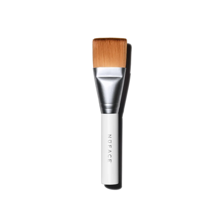 A NuFACE Clean Sweep Applicator Brush with light brown bristles, a silver ferrule, and a white handle with the brand name