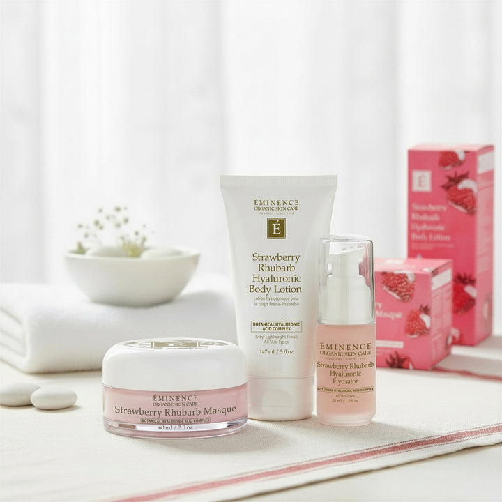 Eminence Organics Strawberry Rhubarb Trio - Limited Edition including a cream, lotion, and serum on a white surface with a pink box in the background.