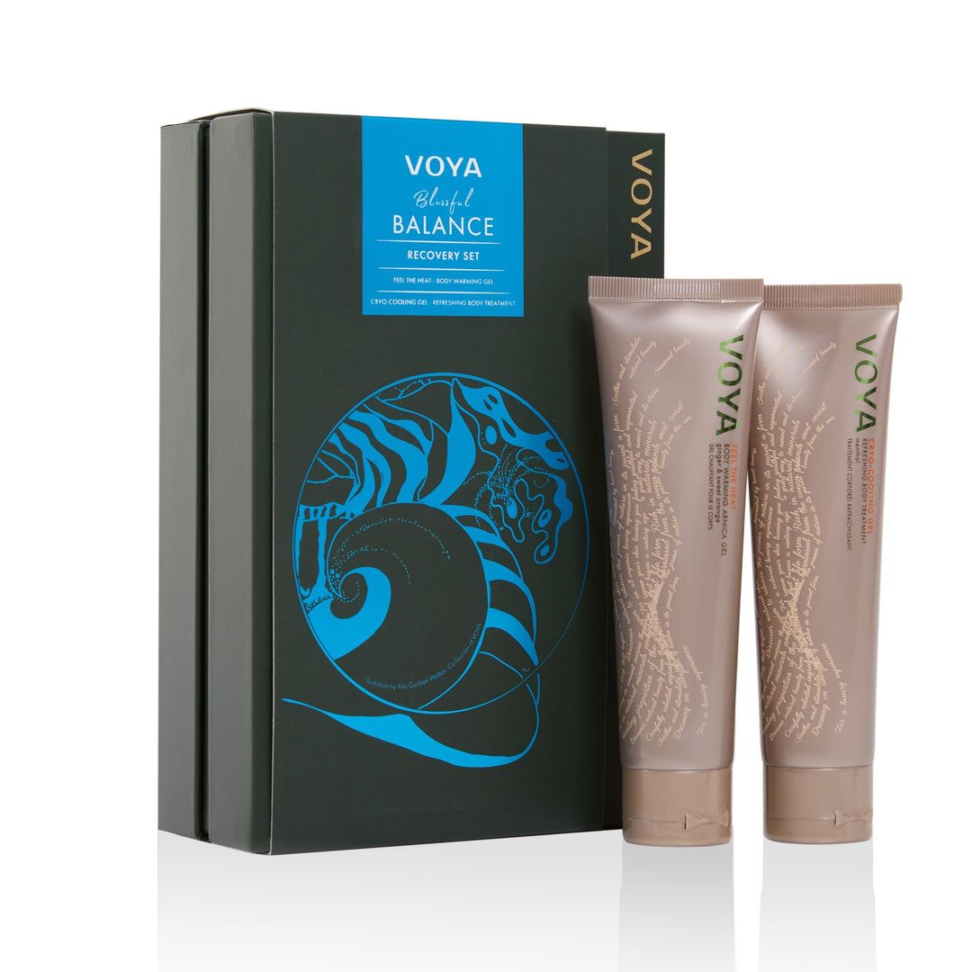 VOYA Blissful Balance Recovery Set with body warming gel and cooling gel beside a dark green gift box with a blue shell illustration.
