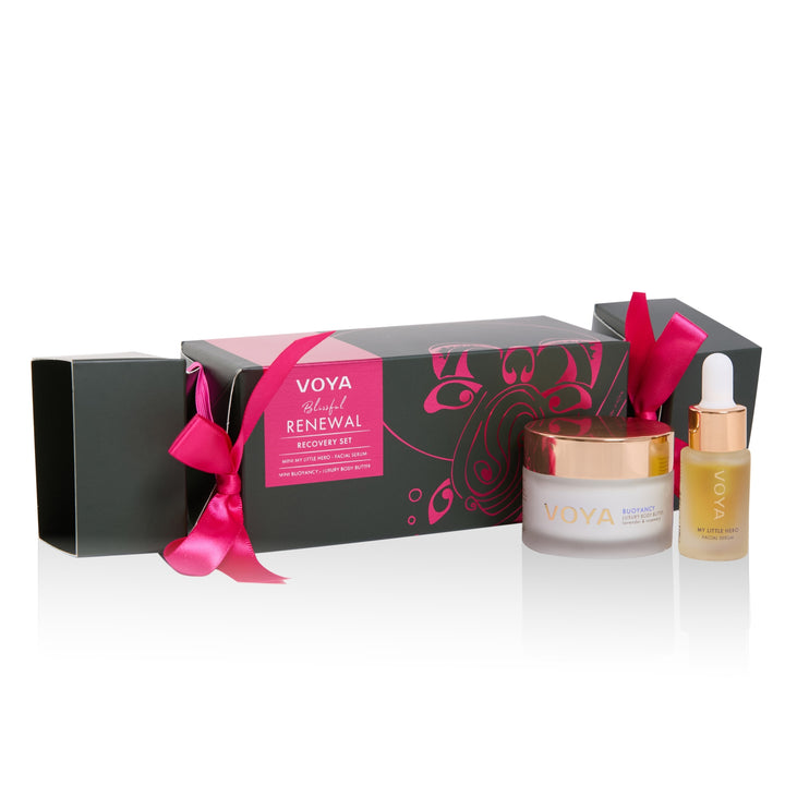VOYA Blissful Renewal Nourishing Mini Set with facial serum, body butter and a cracker-shaped gift box tied with pink ribbons.
