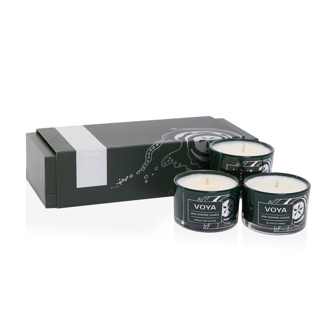 VOYA Blissful Sparks Mini Candle Trio with three dark green glass candles and an illustrated gift box.