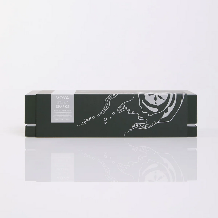 VOYA Blissful Sparks Mini Candle Trio gift box with silver coastal illustrations on dark green packaging.