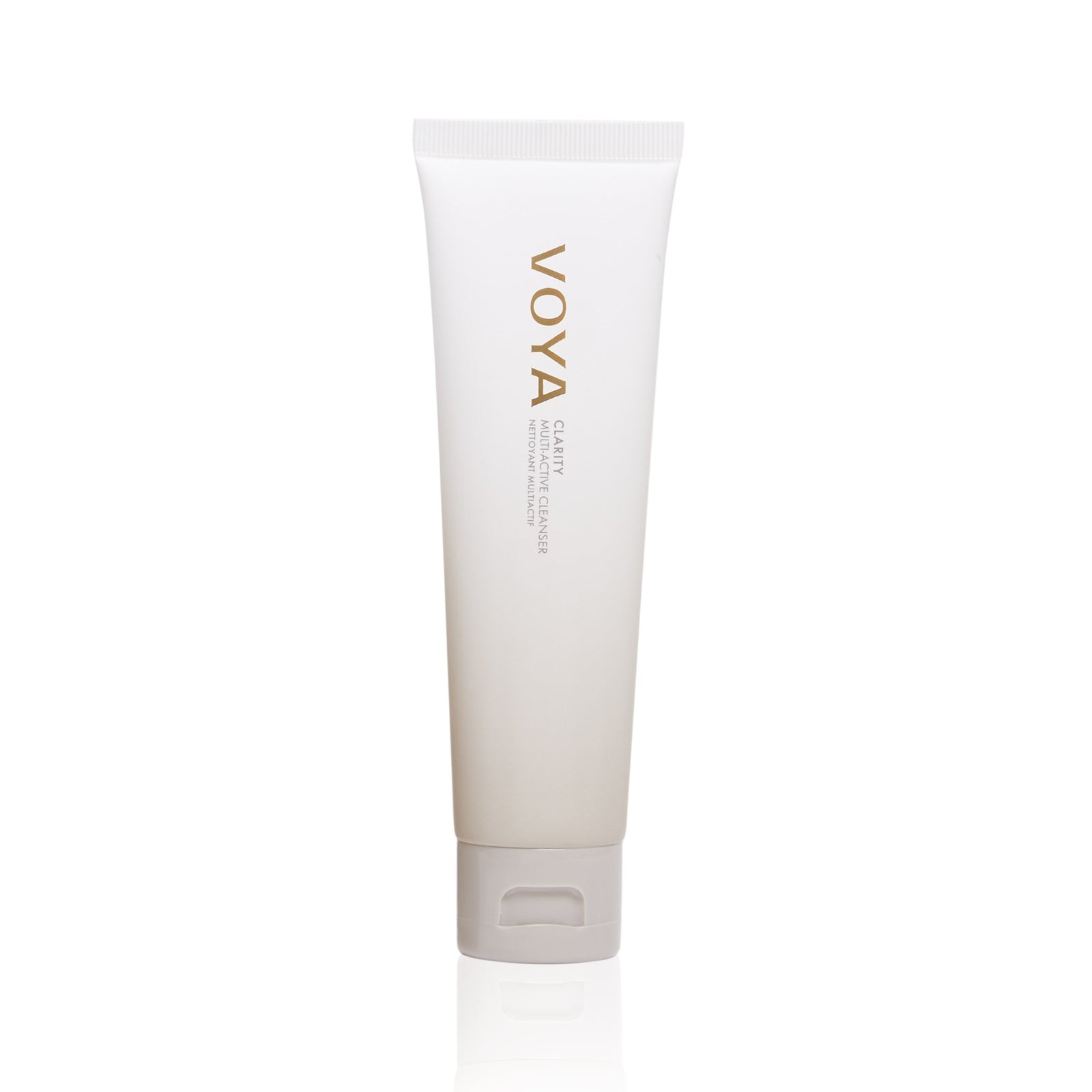 A white squeeze tube of VOYA Clarity: Multi-Active Cleanser with gold lettering, standing upright on a clean white background with a subtle reflection.