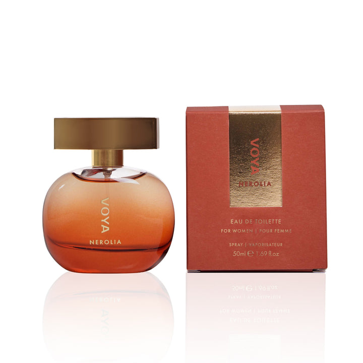 VoYA Nerolia Eau de Toilette perfume bottle in a rounded amber glass shape with a metallic gold cap, shown next to its textured reddish-brown packaging box with a gold vertical band.